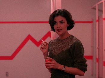 Movie still from “Twin Peaks” (1990), created by David Lynch – A woman holding a can of soda in her hand; Medium shot, Over the shoulder angle