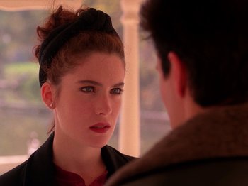 Movie still from “Twin Peaks” (1990), created by David Lynch – A young woman looking at a young man in front of a window; Close Up shot, Over the shoulder angle
