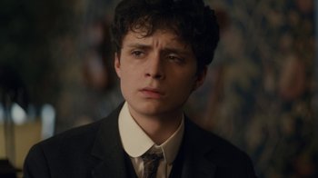 Movie still from “Anne with an E” (2017), created by Moira Walley-Beckett – A young man in a suit and tie looking at the camera; Close Up shot, Low angle