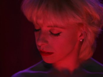 Movie still from “Twin Peaks” (1990), created by David Lynch – A woman with blonde hair and red lighting; Close Up shot, High angle