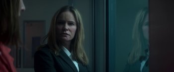 Movie still from “Annihilation” (2018), directed by Alex Garland – A woman wearing a suit and tie standing in front of a window; Close Up shot, Low angle