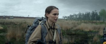 Movie still from “Annihilation” (2018), directed by Alex Garland – A woman with a backpack walking through a field; Close Up shot, Over the shoulder angle