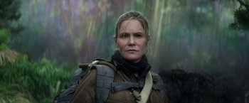 Movie still from “Annihilation” (2018), directed by Alex Garland – A woman in a brown jacket and a black neck scarf; Close Up shot, Low angle