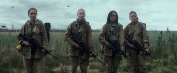 Movie still from “Annihilation” (2018), directed by Alex Garland – A group of men standing next to each other holding guns; Medium shot, Low angle