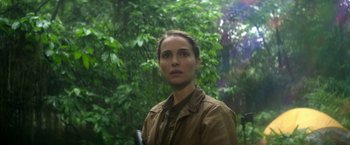 Movie still from “Annihilation” (2018), directed by Alex Garland – A woman standing in front of a forest; Close Up shot, Over the shoulder angle