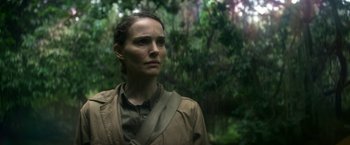 Movie still from “Annihilation” (2018), directed by Alex Garland – A woman standing in the middle of a lush green forest; Close Up shot, Low angle