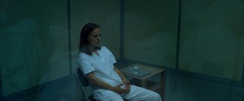 Movie still from “Annihilation” (2018), directed by Alex Garland – A woman sitting in a chair in front of a table; Medium shot, High angle