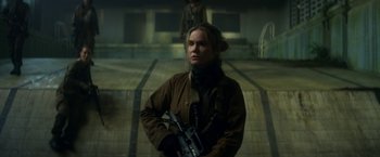 Movie still from “Annihilation” (2018), directed by Alex Garland – A woman holding a gun while standing in a building; Medium shot, Low angle