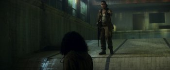Movie still from “Annihilation” (2018), directed by Alex Garland – A woman holding a gun in front of another woman; Wide shot, Over the shoulder angle