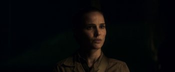 Movie still from “Annihilation” (2018), directed by Alex Garland – A woman in a brown shirt is in the dark; Close Up shot, Low angle