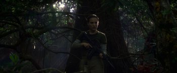 Movie still from “Annihilation” (2018), directed by Alex Garland – A woman holding a rifle in a forest; Medium shot, Low angle