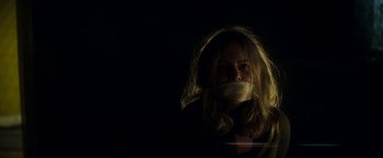 Movie still from “Annihilation” (2018), directed by Alex Garland – A woman with her mouth taped shut in the dark; Close Up shot, Low angle