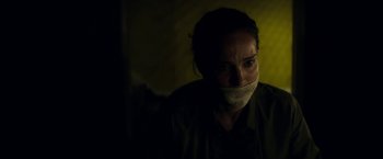 Movie still from “Annihilation” (2018), directed by Alex Garland – A woman with a duct tape over her mouth; Close Up shot, Over the shoulder angle