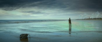Movie still from “Annihilation” (2018), directed by Alex Garland – A person standing on a beach near the ocean; Extreme Wide shot, Low angle