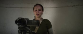 Movie still from “Annihilation” (2018), directed by Alex Garland – A woman in a green shirt is holding a video camera; Close Up shot, Over the shoulder angle