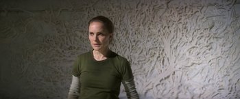 Movie still from “Annihilation” (2018), directed by Alex Garland – A woman standing in front of a white wall; Close Up shot, High angle
