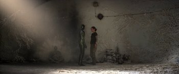 Movie still from “Annihilation” (2018), directed by Alex Garland – A woman standing next to another woman in a room; Wide shot, Over the shoulder angle