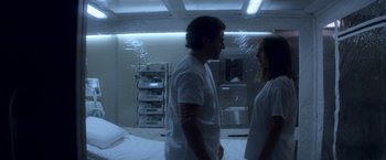 Movie still from “Annihilation” (2018), directed by Alex Garland – A man and a woman standing next to each other in a room; Medium shot, Low angle