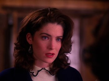 Movie still from “Twin Peaks” (1990), created by David Lynch – A person wearing a necklace; Close Up shot, Over the shoulder angle