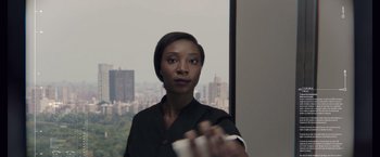 Movie still from “Anon” (2018), directed by Andrew Niccol – A woman holding a remote control in front of a window; Close Up shot, Over the shoulder angle