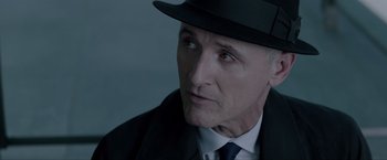 Movie still from “Anon” (2018), directed by Andrew Niccol – An older man wearing a suit and a hat; Close Up shot, Over the shoulder angle