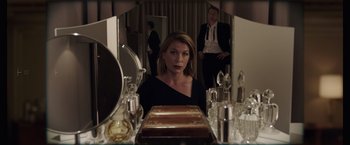 Movie still from “Anon” (2018), directed by Andrew Niccol – A woman sitting in front of a mirror in front of two men; Medium shot, Over the shoulder angle