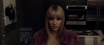 Movie still from “Anon” (2018), directed by Andrew Niccol – A woman in a purple fur coat with long blonde hair; Close Up shot, Over the shoulder angle