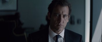 Movie still from “Anon” (2018), directed by Andrew Niccol – A man in a suit and a tie; Close Up shot, Over the shoulder angle