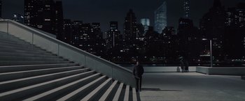 Movie still from “Anon” (2018), directed by Andrew Niccol – A man standing on the steps of a building; Extreme Wide shot, High angle