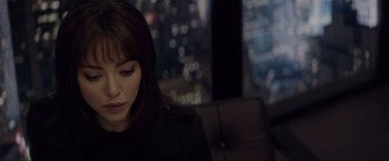 Movie still from “Anon” (2018), directed by Andrew Niccol – A woman sitting in front of a window in a dark room; Close Up shot, Over the shoulder angle