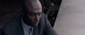Movie still from “Anon” (2018), directed by Andrew Niccol – A man in a suit and tie looking to his left; Close Up shot, High angle