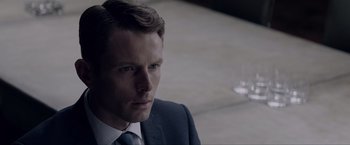 Movie still from “Anon” (2018), directed by Andrew Niccol – A person wearing a suit and tie; Close Up shot, Over the shoulder angle