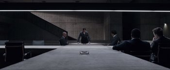 Movie still from “Anon” (2018), directed by Andrew Niccol – A group of people sitting around a table; Wide shot, High angle