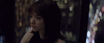 Movie still from “Anon” (2018), directed by Andrew Niccol – A young woman with dark hair looking to her left; Close Up shot, Over the shoulder angle