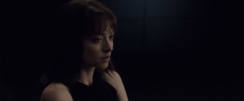 Movie still from “Anon” (2018), directed by Andrew Niccol – A woman in a black shirt is looking at the camera; Close Up shot, Over the shoulder angle