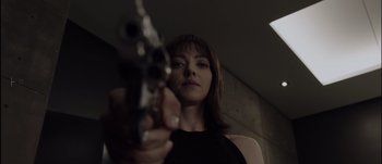 Movie still from “Anon” (2018), directed by Andrew Niccol – A woman is holding a gun in her hand; Close Up shot, Low angle