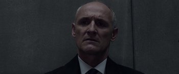 Movie still from “Anon” (2018), directed by Andrew Niccol – An older man wearing a suit and tie; Close Up shot, Low angle