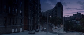 Movie still from “Anon” (2018), directed by Andrew Niccol – A person walking down a street at night; Extreme Wide shot, High angle