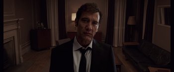 Movie still from “Anon” (2018), directed by Andrew Niccol – A person wearing a suit and tie; Close Up shot, Low angle