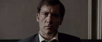 Movie still from “Anon” (2018), directed by Andrew Niccol – A person wearing a suit and tie; Close Up shot, Low angle