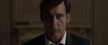 Movie still from “Anon” (2018), directed by Andrew Niccol – A person wearing a suit and tie; Close Up shot, Low angle