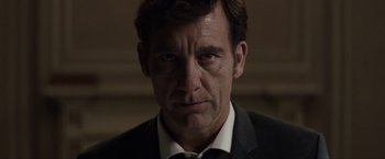 Movie still from “Anon” (2018), directed by Andrew Niccol – A person wearing a suit and tie; Close Up shot, Low angle