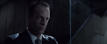 Movie still from “Anon” (2018), directed by Andrew Niccol – A man in a suit and tie; Close Up shot, Low angle