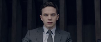 Movie still from “Anon” (2018), directed by Andrew Niccol – A man wearing a suit and tie in front of a wall; Close Up shot, Over the shoulder angle