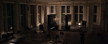 Movie still from “Anon” (2018), directed by Andrew Niccol – A room filled with lots of furniture and a chandelier; Wide shot, High angle