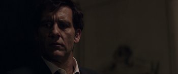 Movie still from “Anon” (2018), directed by Andrew Niccol – A person wearing a suit and tie; Close Up shot, Low angle