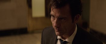 Movie still from “Anon” (2018), directed by Andrew Niccol – A person wearing a suit and tie; Close Up shot, Over the shoulder angle