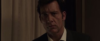 Movie still from “Anon” (2018), directed by Andrew Niccol – A person wearing a suit and tie; Close Up shot, Low angle