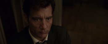 Movie still from “Anon” (2018), directed by Andrew Niccol – A person wearing a suit and tie; Close Up shot, Low angle