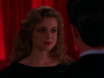 Movie still from “Twin Peaks” (1990), created by David Lynch – A woman in a black dress looking at a man in a black suit; Close Up shot, Over the shoulder angle